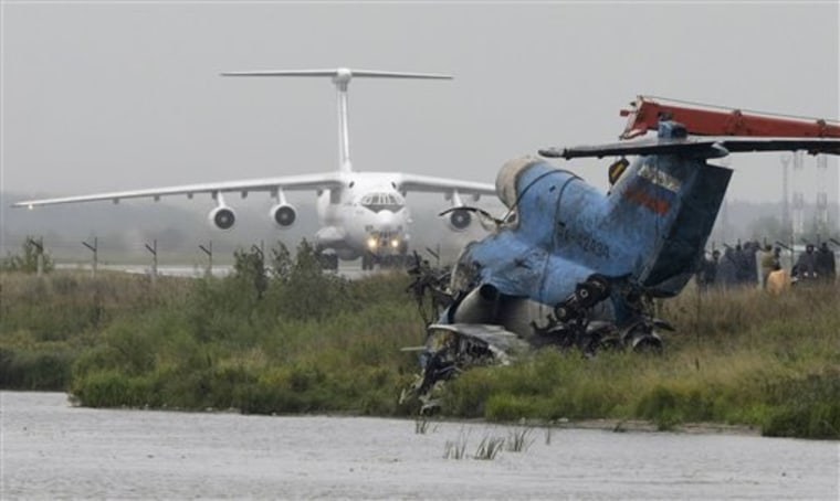 In this Sept. 9 photo, debris of the crashed Yak-42 jet is seen in foreground as a plane lands at an airport near Yaroslavl, 150 miles northeast of Moscow in Russia. 